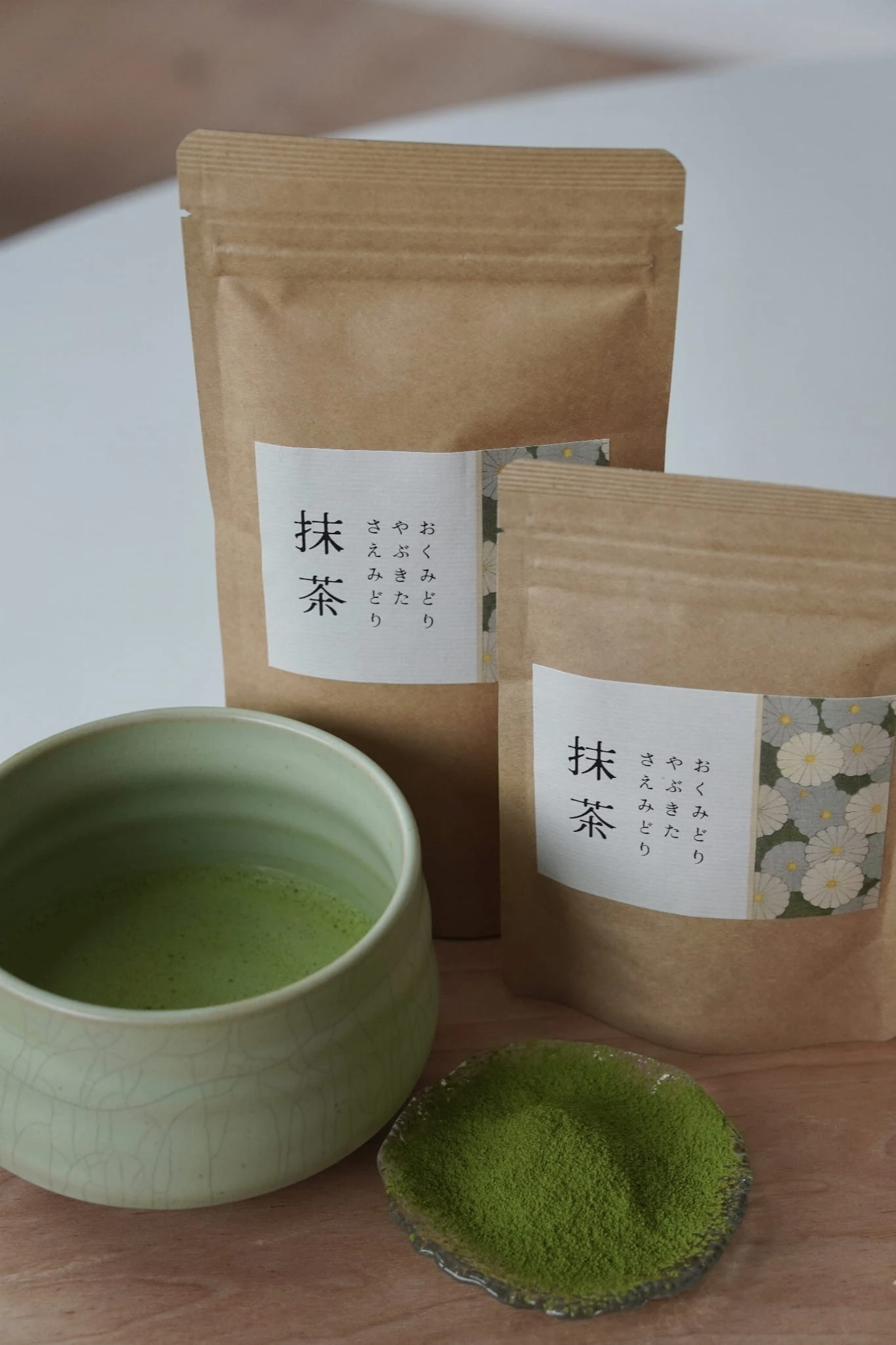 Opakowanie japońskiej rzemieślniczej herbaty Matcha Miyazaki obok ceramicznej czarki Meico Studio